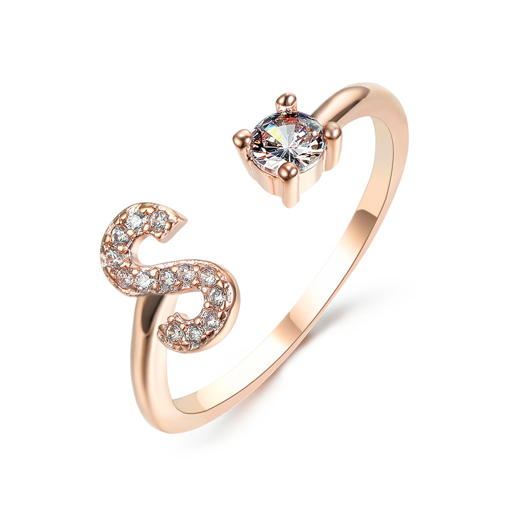 Rose gold adjustable initial ring with curved open letter shape and round center stone.