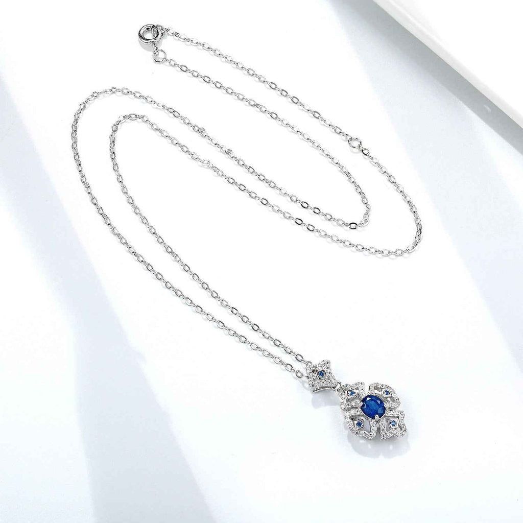 Silver chain necklace with oval blue sapphire floral pendant