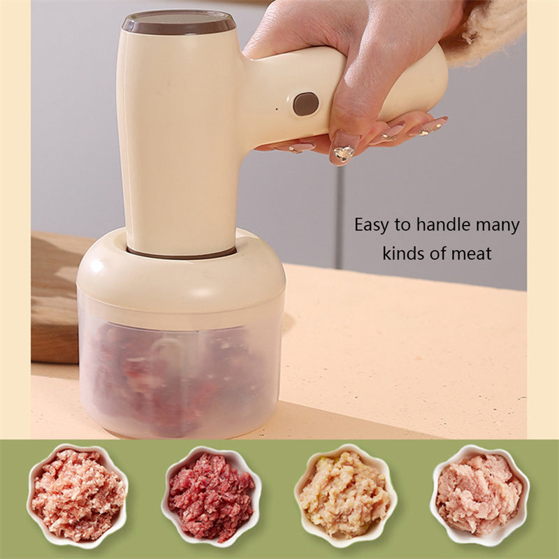 Beige electric chopper with hand filling a clear cup