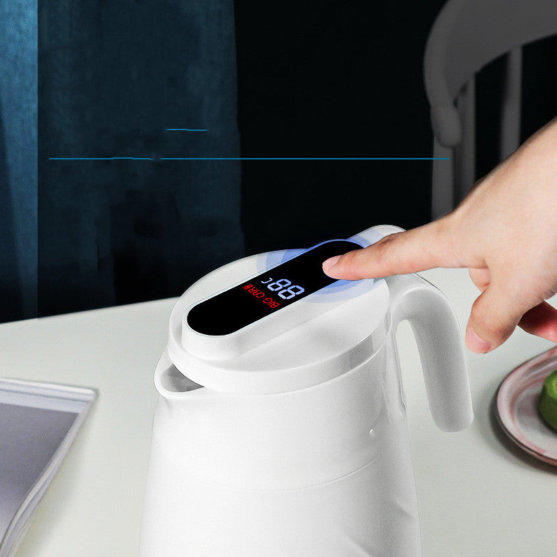 White smart water bottle with digital screen on side, hand reaching toward lid