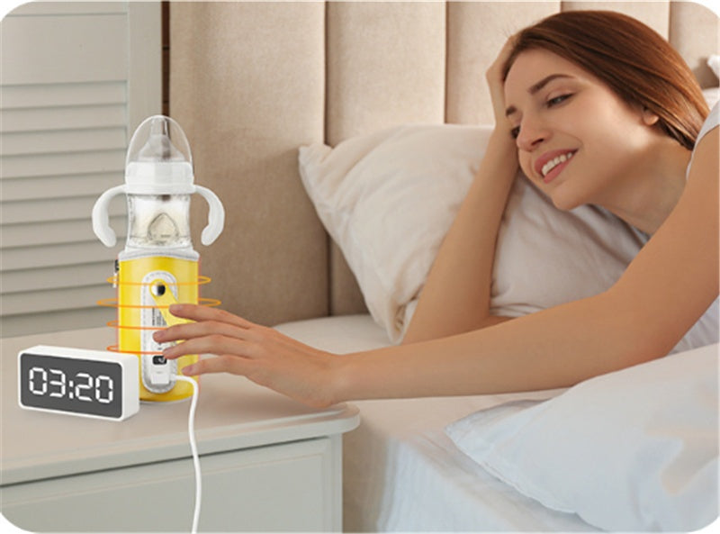 Yellow baby milk bottle warmer with screen, next to glass bottle and feeding set