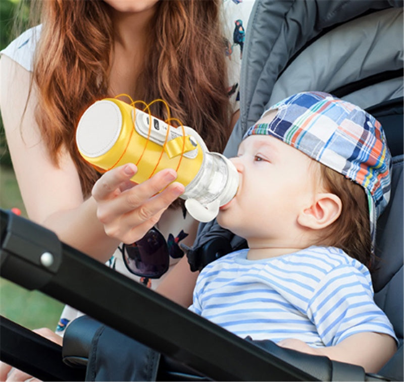 Yellow baby milk bottle warmer held near a seated baby during feeding