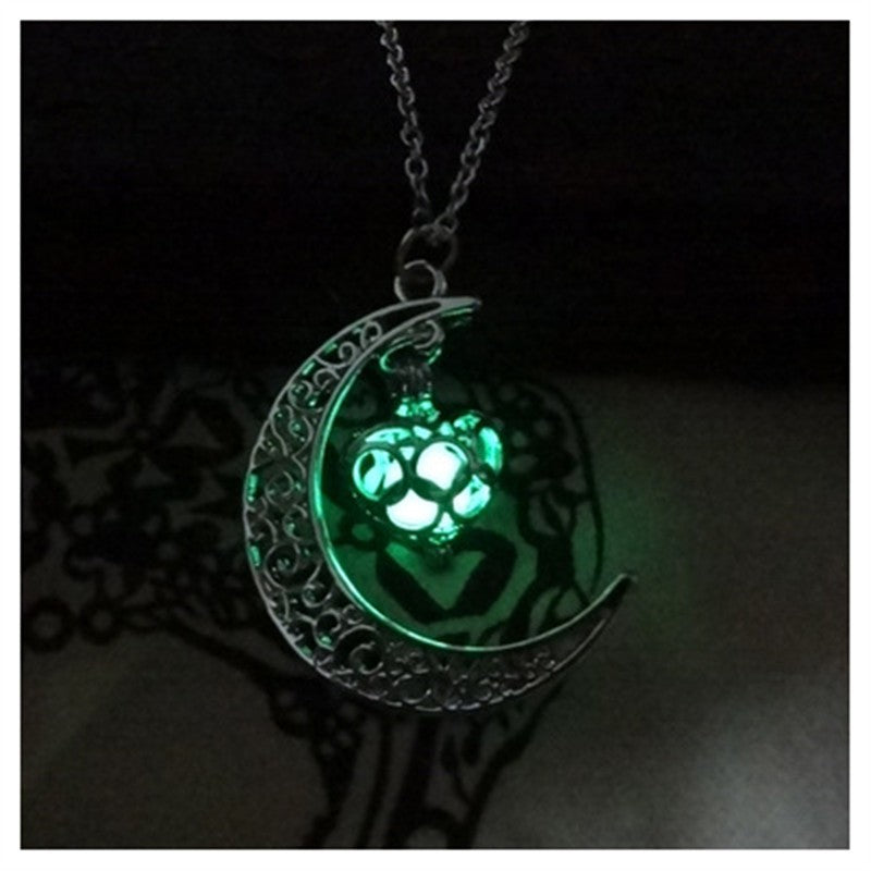 Crescent moon pendant necklace with green glowing cat paw on a silver chain