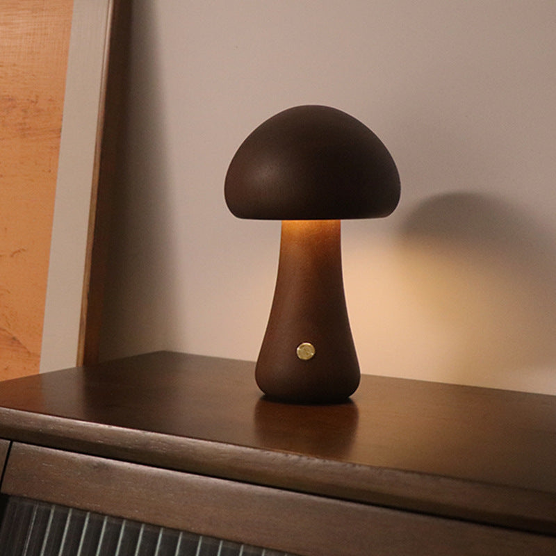 Dark wooden mushroom LED night light on a cabinet shelf, glowing warm light