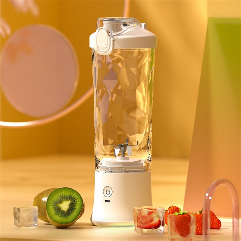 Portable blender with clear blending bottle and white base, shown with fruit pieces