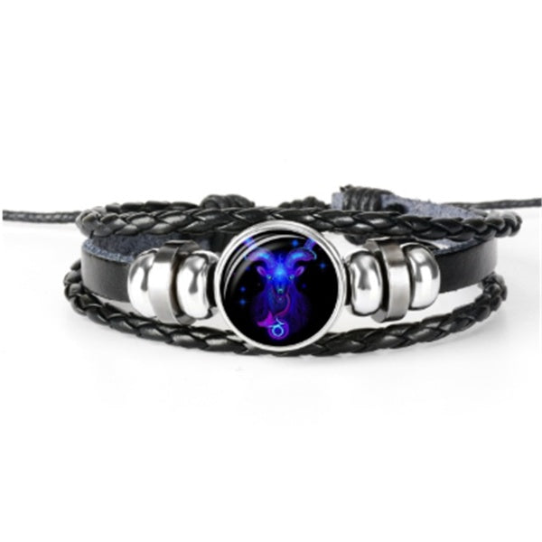 Braided leather-look bracelet featuring a centered round glowing zodiac charm in a metal frame.