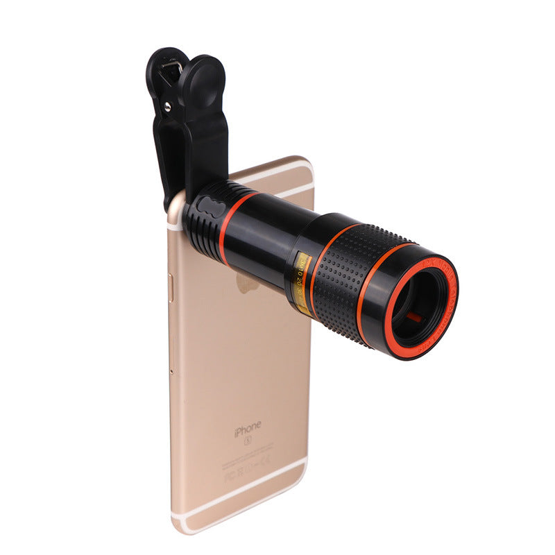 Black clip-on telescope camera lens on gold smartphone back with orange ring