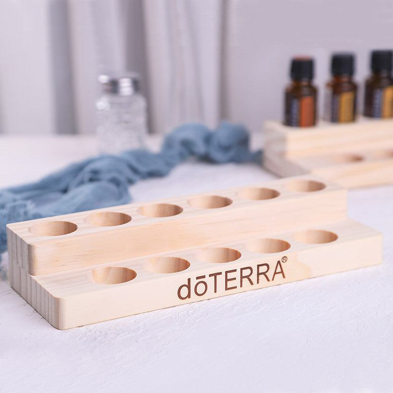Essential oil display stand with 3-tier bottle slots, light wood, dōTERRA logo on front