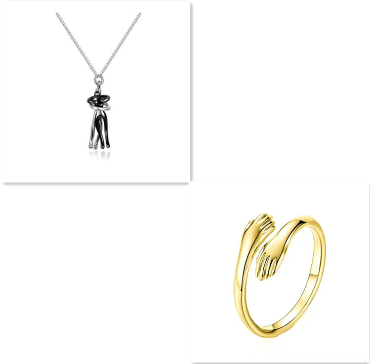 Black and silver hug-pendant necklace with silver chain and gold-tone ring, smooth finish