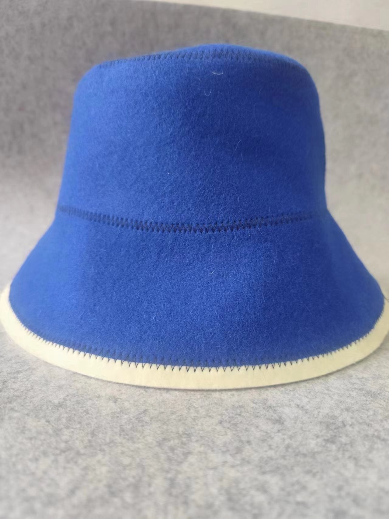 Blue wool fisherman bucket hat with off-white brim and contrast edge stitching