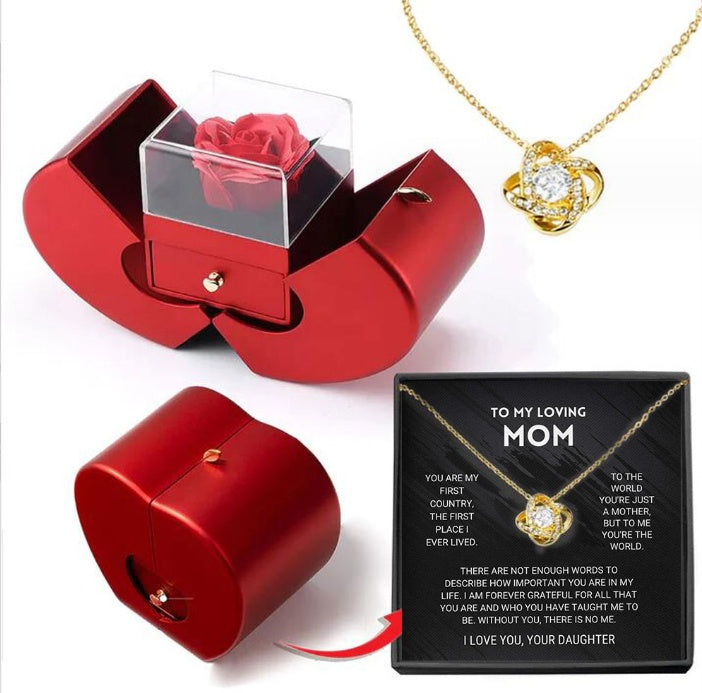 Red jewelry box with clear cover and red rose; gold heart pendant necklace displayed
