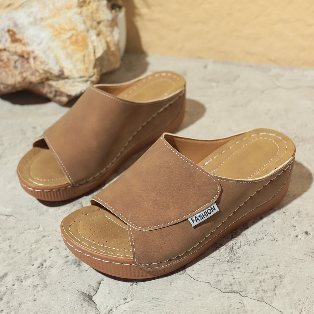 Women’s tan wedge slides with open toe, stitched straps, and brown platform sole